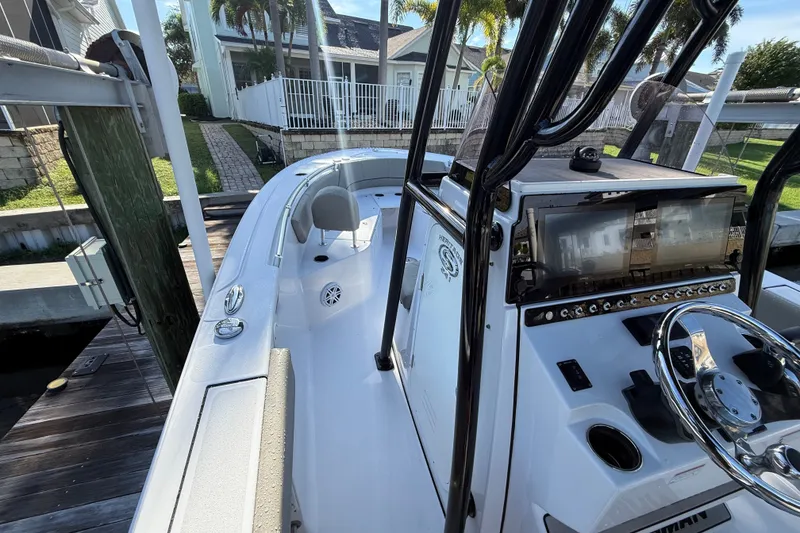 Slide: The Image of 2023 Sportsman Heritage 241 Center Console boat docked, showcasing helm and seating area. - 26