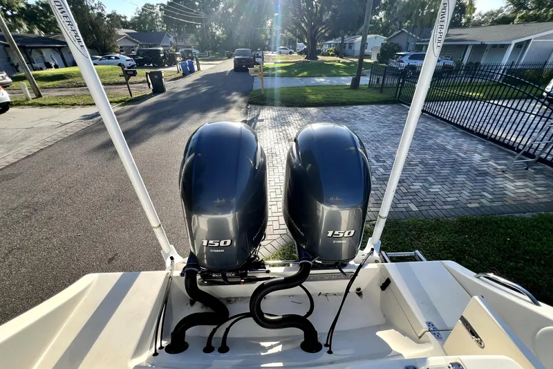 Slide: The Image of 2021 Cobia 240 Center Console with twin Yamaha 150 engines, parked in a residential area. - 35