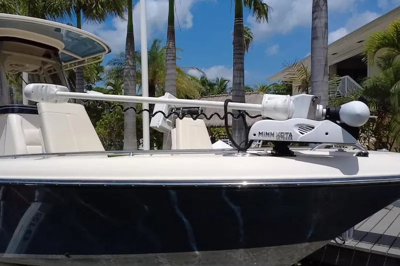 Slide: The Image of 2021 Grady-White 251 Coastal Explorer with Minn Kota trolling motor, docked near palm trees. - 23