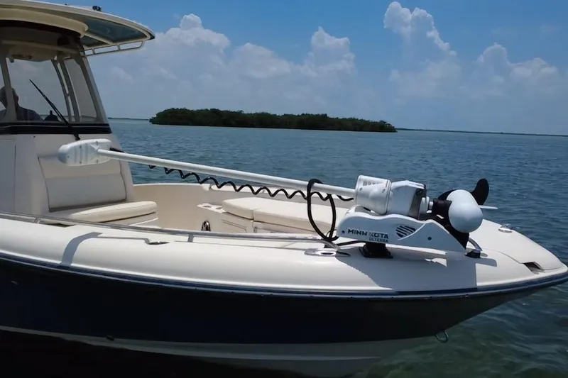 Slide: The Image of 2021 Grady-White 251 Coastal Explorer boat with Minn Kota trolling motor on calm water. - 33