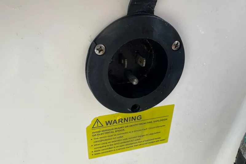 Slide: The Image of Close-up of a 2021 Grady-White 251 Coastal Explorer power outlet with warning label. - 93