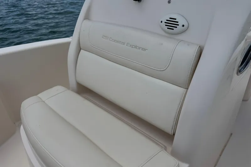Slide: The Image of 2021 Grady-White 251 Coastal Explorer boat seat, white leather, near water. - 69