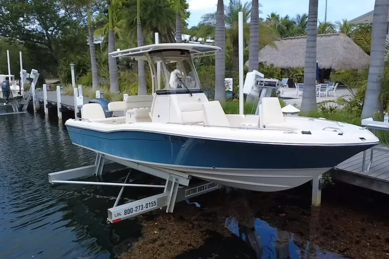 The Image of 2021 Grady-White 251 Coastal Explorer boat docked near palm trees. - 0