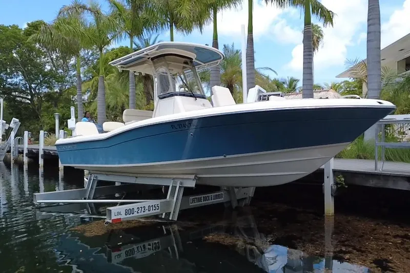 Slide: The Image of 2021 Grady-White 251 Coastal Explorer boat on lift, surrounded by palm trees. - 21