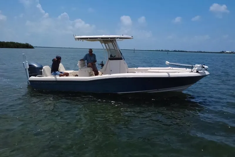 Slide: The Image of 2021 Grady-White 251 Coastal Explorer boat on calm water under a clear blue sky. - 25