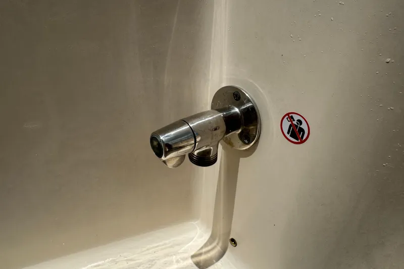 Slide: The Image of Boat interior detail of a 2021 Grady-White 251 Coastal Explorer with a metal fitting and warning sticker. - 80