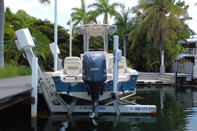 Slide: The Image of 2021 Grady-White 251 Coastal Explorer boat docked near tropical palm trees. - 18