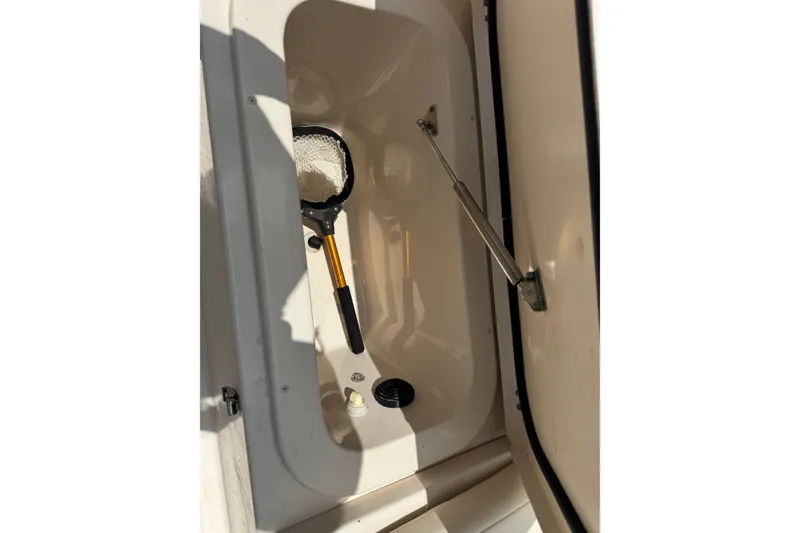 Slide: The Image of Storage compartment of 2021 Grady-White 251 Coastal Explorer with fishing net inside. - 57
