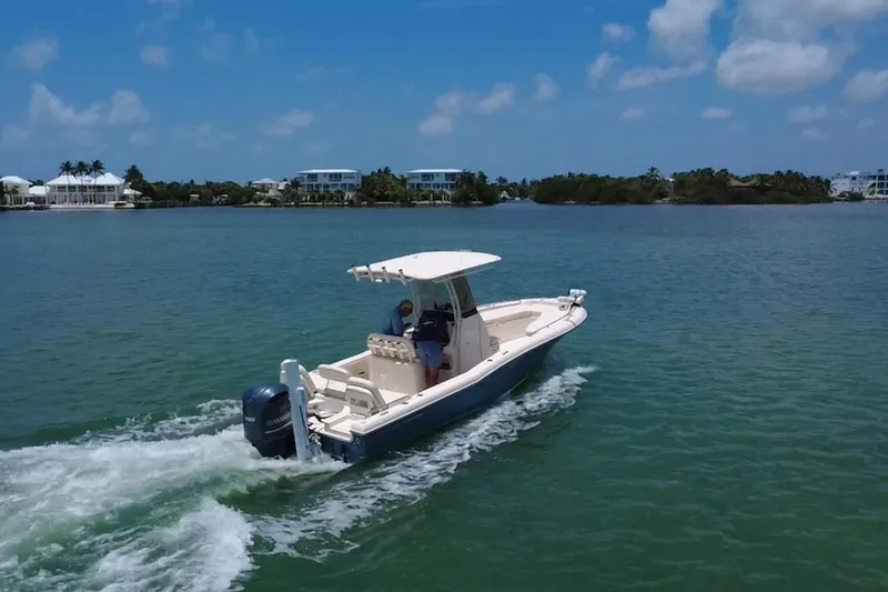 Slide: The Image of 2021 Grady-White 251 Coastal Explorer cruising on a sunny day near waterfront homes. - 38
