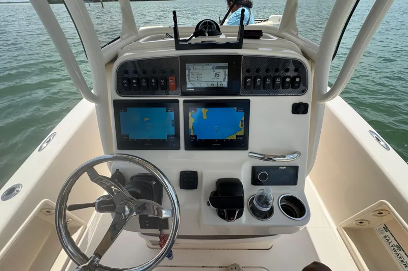 Slide: The Image of 2021 Grady-White 251 Coastal Explorer boat dashboard with navigation screens and controls. - 58