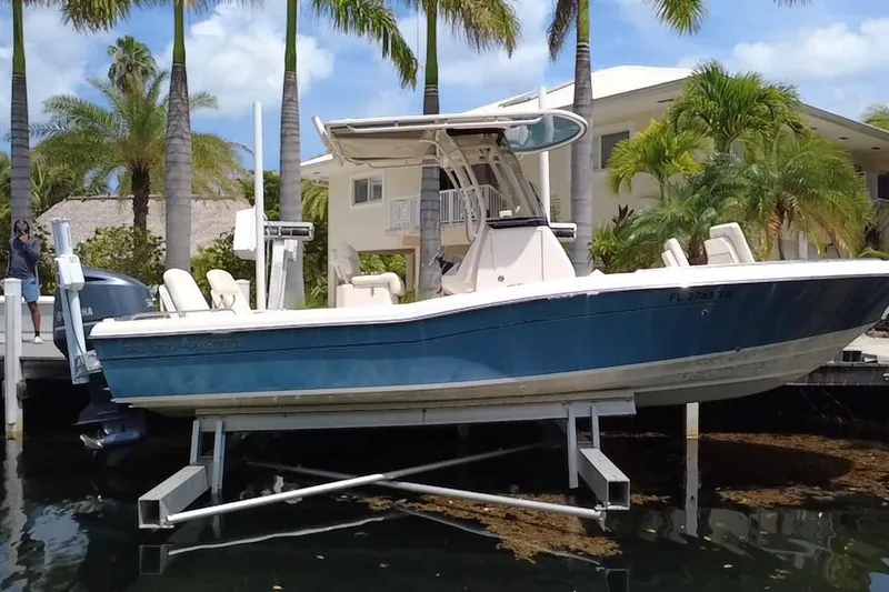 Slide: The Image of 2021 Grady-White 251 Coastal Explorer boat on lift, surrounded by palm trees. - 20
