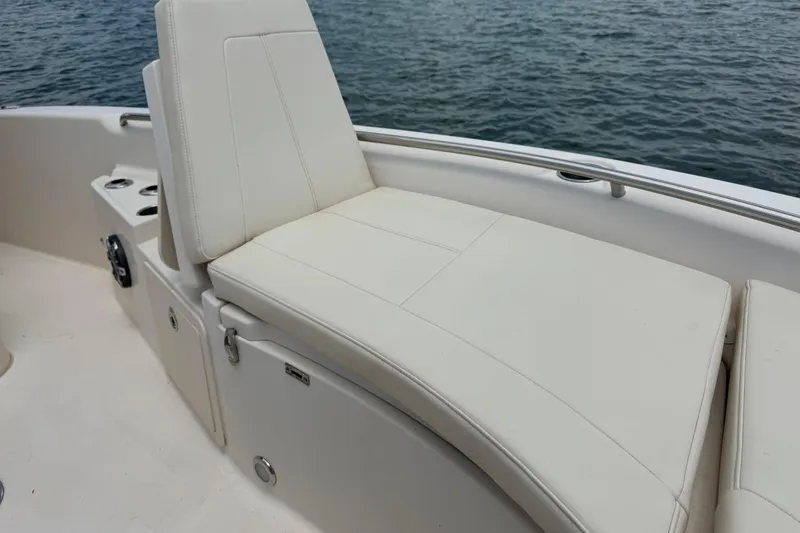 Slide: The Image of 2021 Grady-White 251 Coastal Explorer boat with white cushioned seating by the water. - 72
