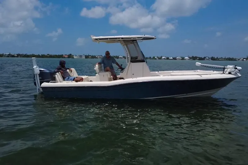 Slide: The Image of 2021 Grady-White 251 Coastal Explorer boat on calm water under blue sky. - 26