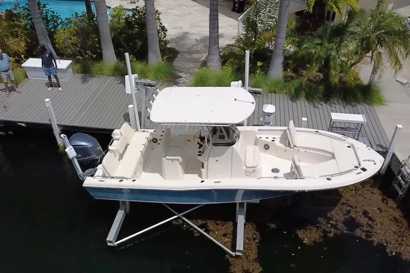 Slide: The Image of 2021 Grady-White 251 Coastal Explorer boat docked near palm trees. - 13