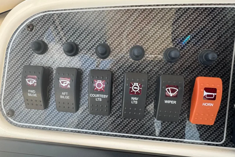 Slide: The Image of Control panel of a 2021 Grady-White 251 Coastal Explorer boat with labeled switches. - 64