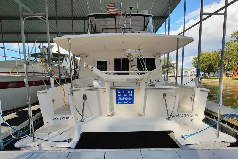 Slide: The Image of A white catamaran docked under a covered area, featuring a platform and several ropes. - 3