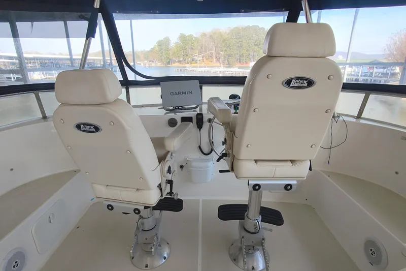 Slide: The Image of Two white captain's chairs in the helm of a 2009 Maine Cat P-47. - 19