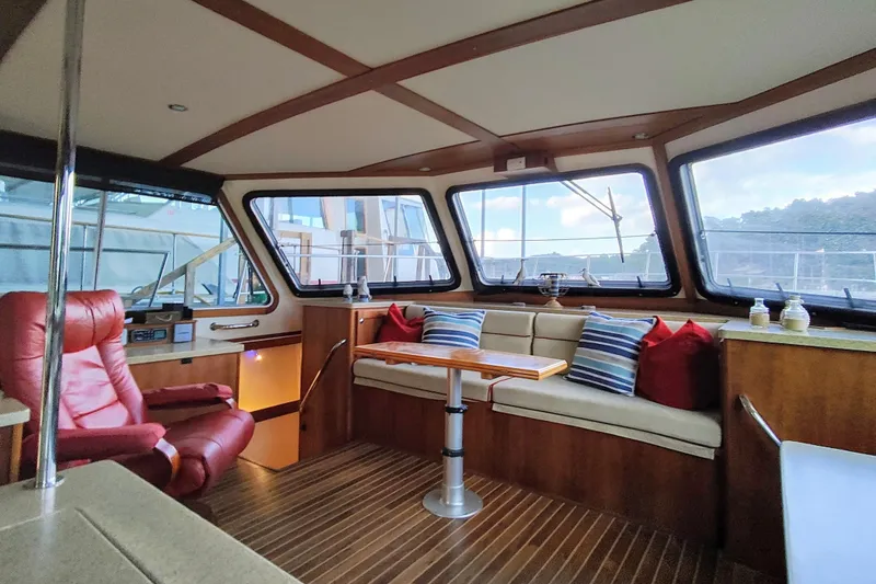 Slide: The Image of Interior of a yacht with wooden flooring, red cushions, and large windows. - 33
