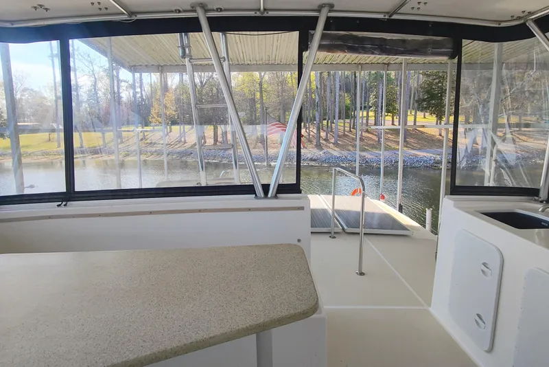 Slide: The Image of Interior of a 2009 Maine Cat P-47 with a view of a calm river and trees. - 21