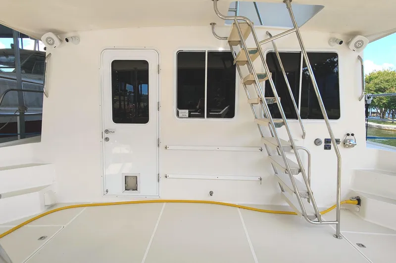 Slide: The Image of The image shows the deck of a 2009 Maine Cat P-47 with a metal ladder and door. - 4