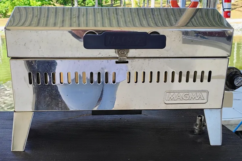 Slide: The Image of A shiny stainless steel grill on a boat, surrounded by water and trees. - 24