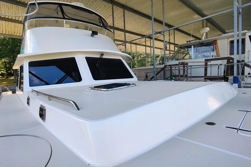 Slide: The Image of A 2009 Maine Cat P-47 in a covered area. It features a spacious deck and large windows. - 10