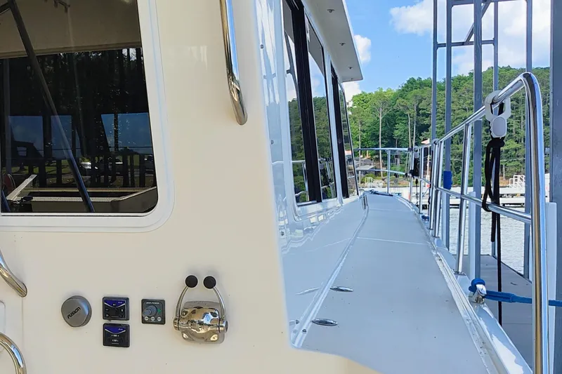 Slide: The Image of Side view of a 2009 Maine Cat P-47 yacht docked by a scenic lake. - 6