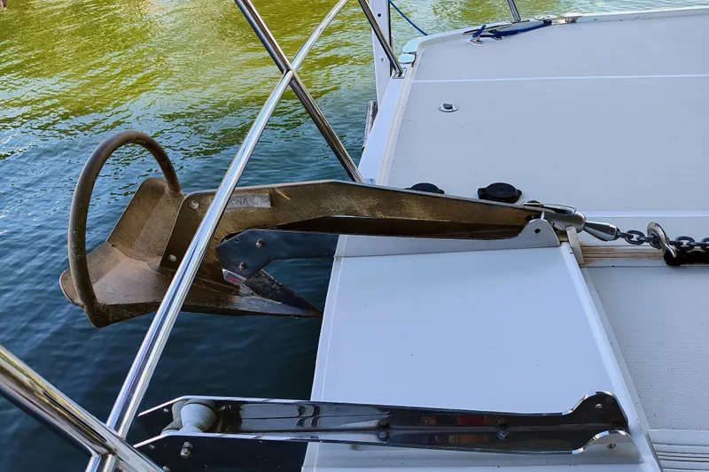Slide: The Image of An anchor is attached to the front of a boat, resting on calm water. - 14