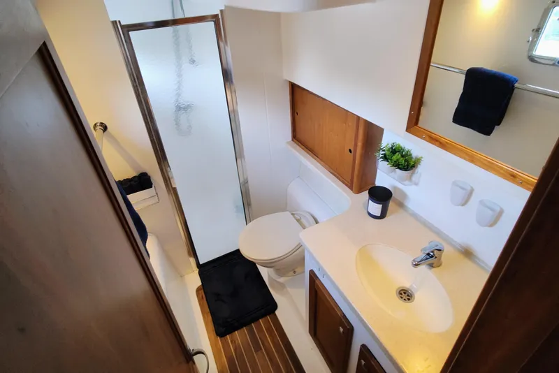 Slide: The Image of The image shows a boat bathroom with a shower, toilet, and sink. - 46