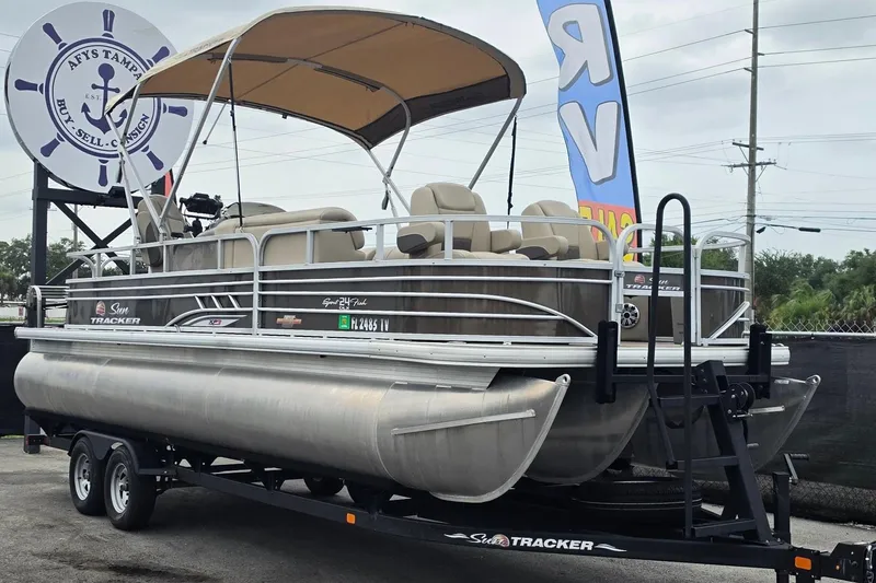 The Image of 2023 Sun Tracker Sportfish 24 XP3 pontoon boat on trailer at dealership. - 0