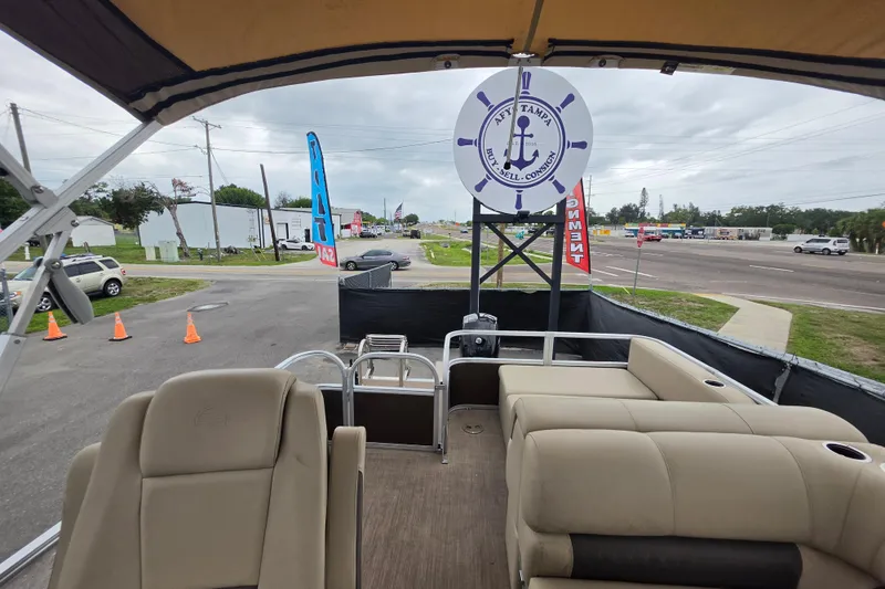 Slide: The Image of 2023 Sun Tracker Bass Buggy 18 DLX pontoon boat at dealership, showcasing seating and helm. - 45