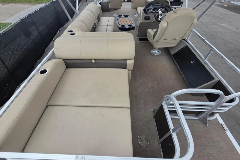 Slide: The Image of 2023 Sun Tracker Bass Buggy 18 DLX pontoon boat interior with beige seating and steering console. - 16