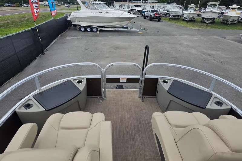 Slide: The Image of 2023 Sun Tracker Bass Buggy 18 DLX pontoon boat at dealership, surrounded by other boats. - 29