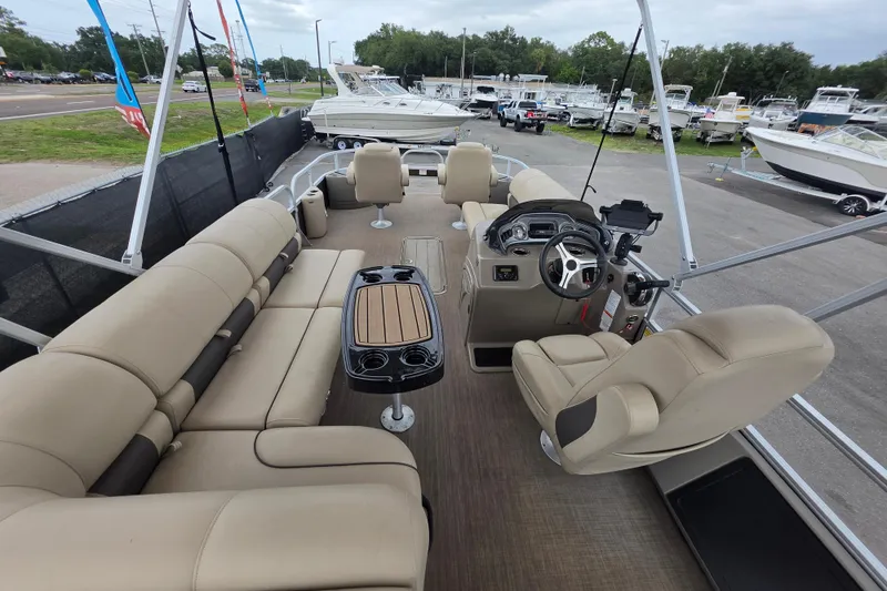 Slide: The Image of 2023 Sun Tracker Bass Buggy 18 DLX pontoon boat interior with beige seating and steering console. - 15