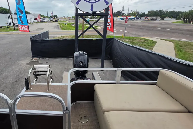 Slide: The Image of 2023 Sun Tracker Bass Buggy 18 DLX pontoon boat at a sales lot with signage. - 46