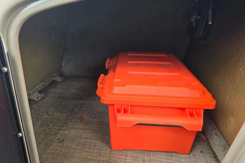 Slide: The Image of Storage compartment with orange container in 2023 Sun Tracker Bass Buggy 18 DLX boat. - 44