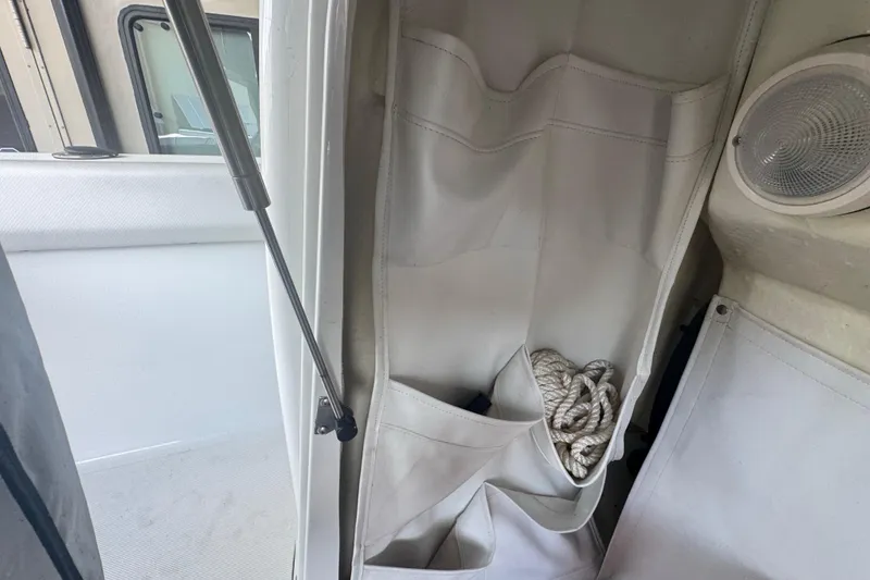 Slide: The Image of Interior of 2023 Wellcraft 242 Fisherman boat with storage pocket and rope. - 56