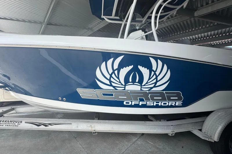 Slide: The Image of 2023 Wellcraft 242 Fisherman boat with Scarab Offshore logo on trailer. - 3