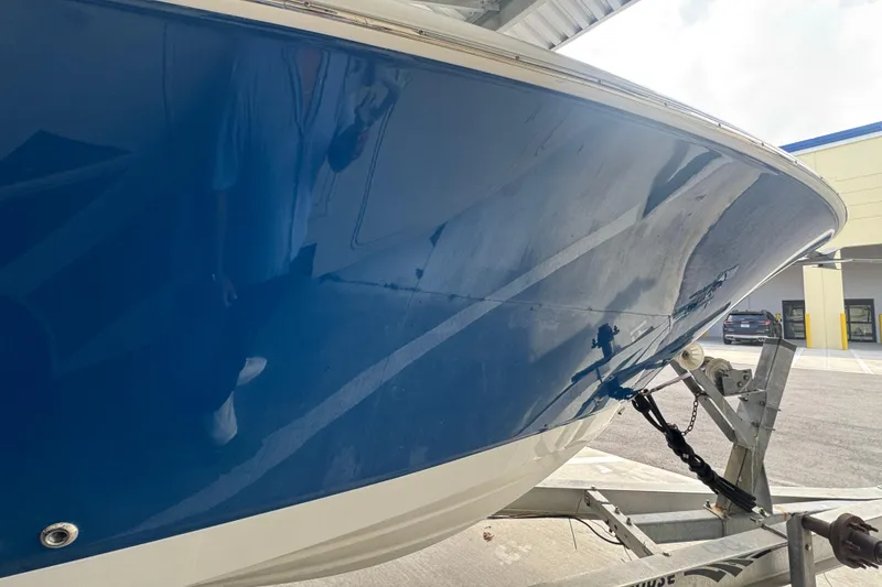 Slide: The Image of 2023 Wellcraft 242 Fisherman boat on trailer, blue hull, parked outdoors. - 19