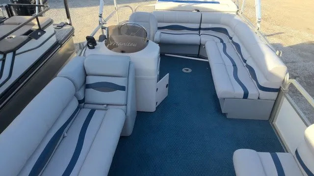 Slide: The Image of The image shows the interior of a 2008 Manitou OASIS 20 pontoon boat with blue and white seating. - 5