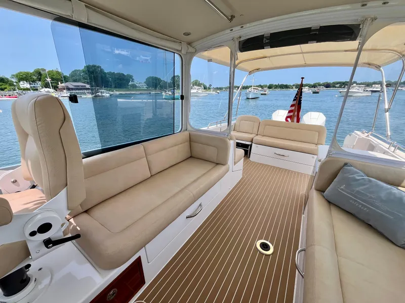 Slide: The Image of Luxurious 2019 MJM 35z boat interior with beige seating and scenic waterfront view. - 46