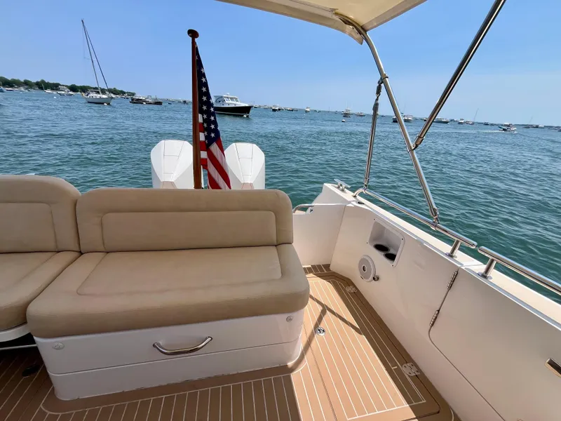 Slide: The Image of 2019 MJM 35z boat interior with beige seating, American flag, and ocean view. - 41
