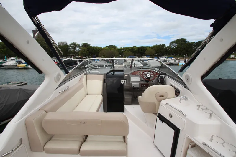 Slide: The Image of 2011 Regal 2860 Window Express boat interior with seating and helm, docked in a marina. - 13
