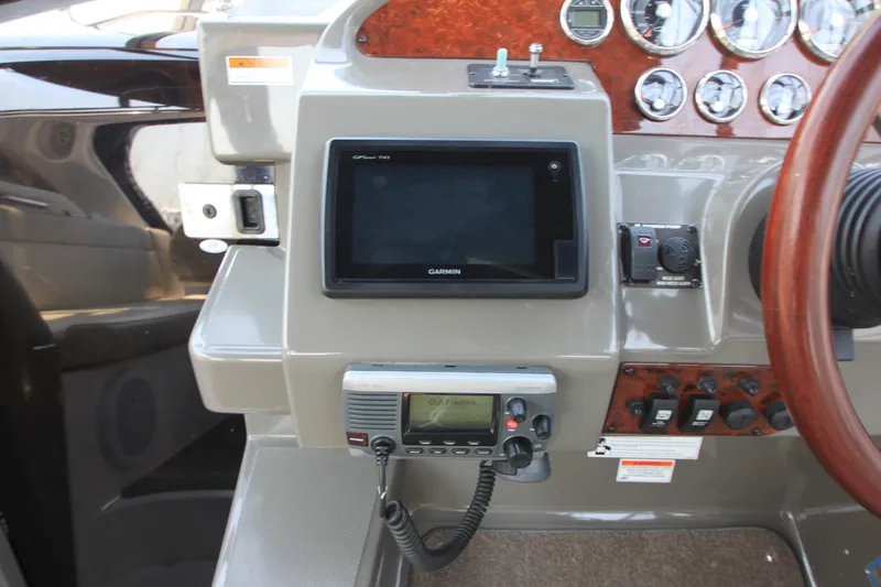 Slide: The Image of Das Bild zeigt das Armaturenbrett eines Regal 2860 Window Express Bootes von 2011 mit verschiedenen Instrumenten und einem Garmin-Display. - 3