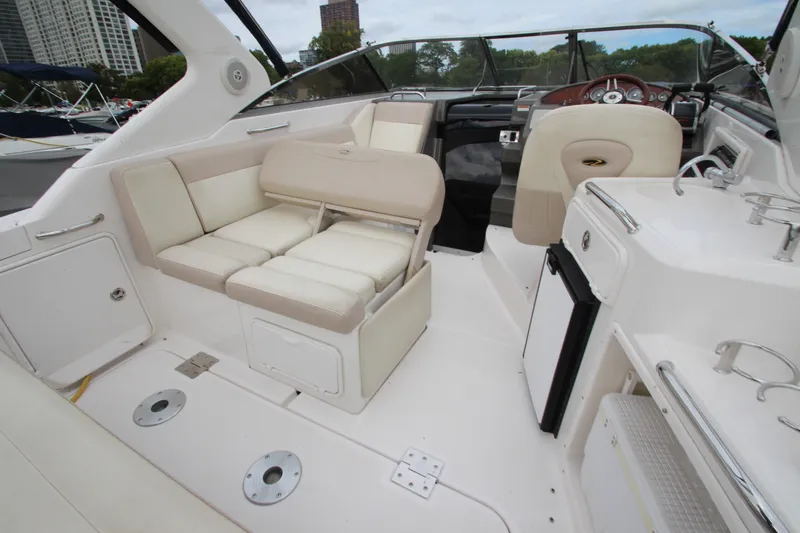 Slide: The Image of 2011 Regal 2860 Window Express boat interior with seating and helm, docked in a marina. - 24