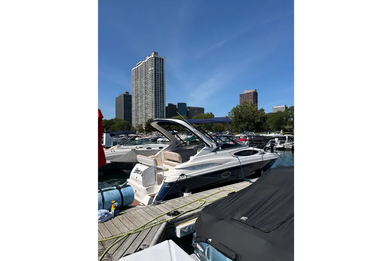 Slide: The Image of 2011 Regal 2860 Window Express boat docked in urban marina with city skyline. - 31