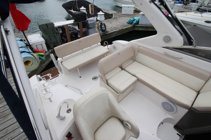 Slide: The Image of 2011 Regal 2860 Window Express boat interior with beige seating and dockside view. - 15