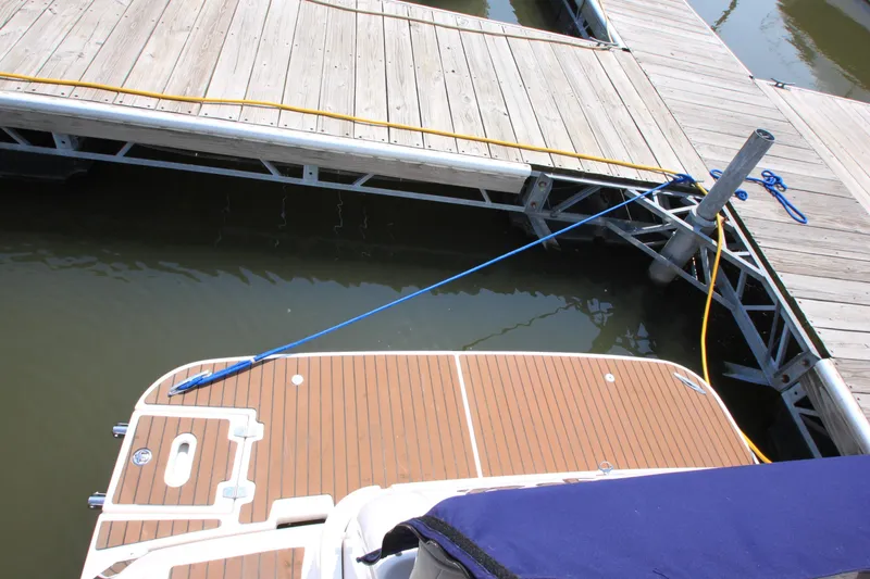 Slide: The Image of Das Bild zeigt das Heck eines Bootes mit einer Holzplattform, das an einem Dock festgemacht ist. - 23