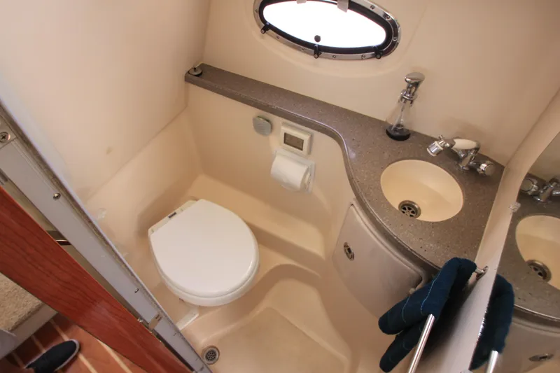 Slide: The Image of Das Bild zeigt ein Badezimmer auf einem Boot mit Toilette, Waschbecken und Bullauge. - 21