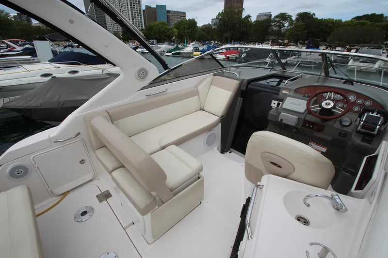 Slide: The Image of 2011 Regal 2860 Window Express boat interior with helm, seating, and marina view. - 14
